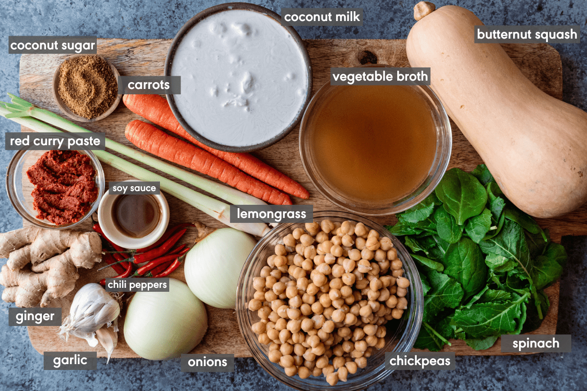 labeled ingredients for butternut squash curry on wooden cutting board.