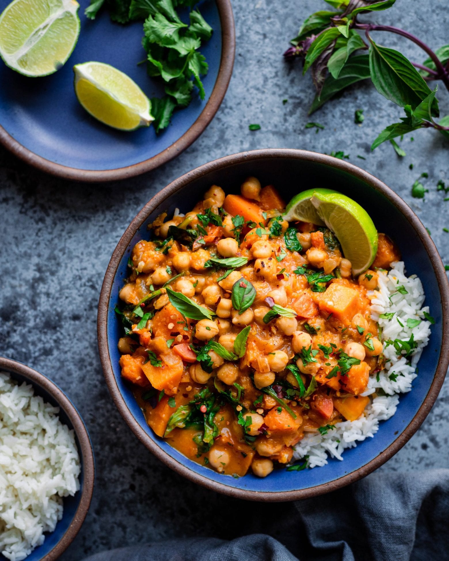 Thai butternut squash curry in blue bowl with rice and lime