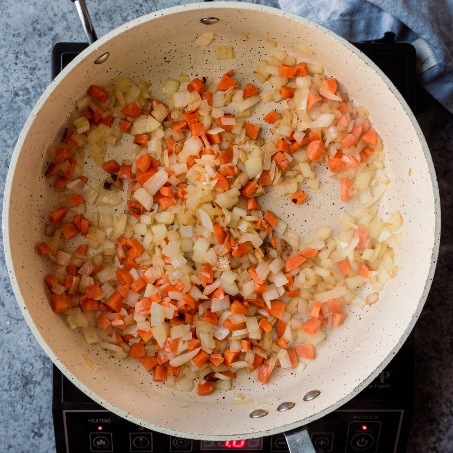 sauteed onions and carrots in frying pan