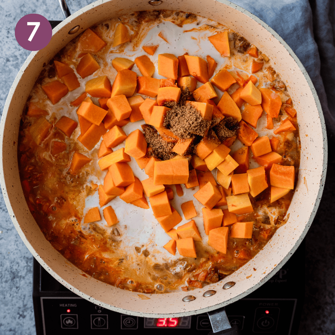 diced butternut squash and coconut sugar sitting on top of a thai red curry. 