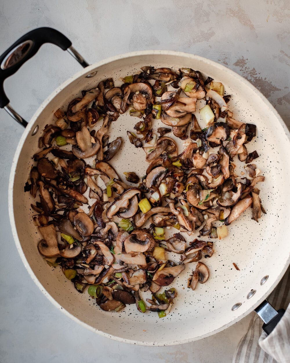 mushrooms and leeks sautéing in pan