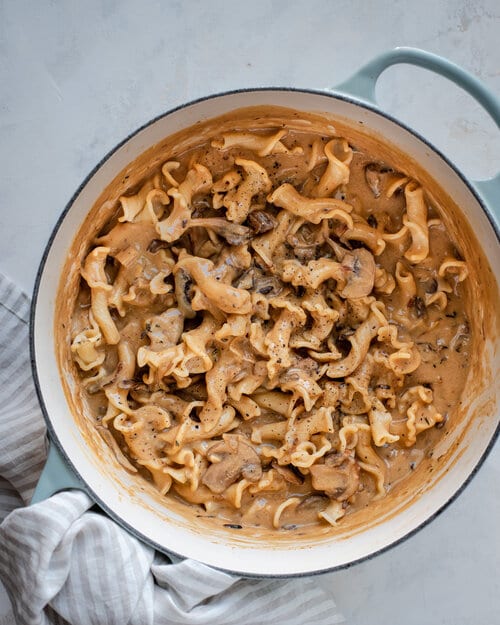 pasta being tossed in stroganoff sauce