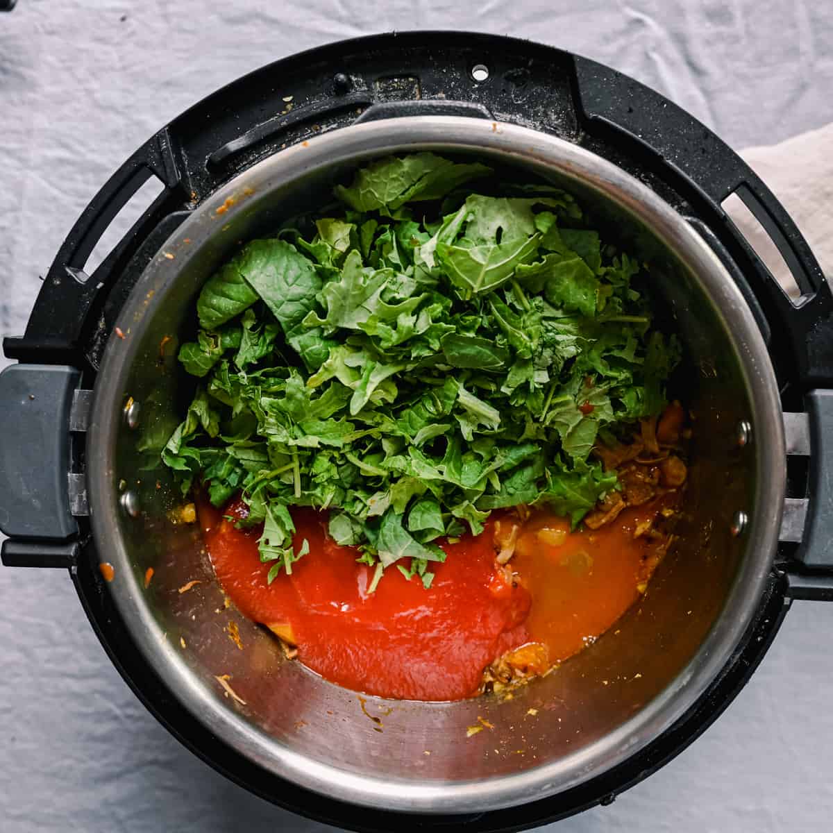 tomato sauce and kale sitting in instant pot jackfruit curry