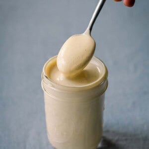 spooning cashew cream over glass jar