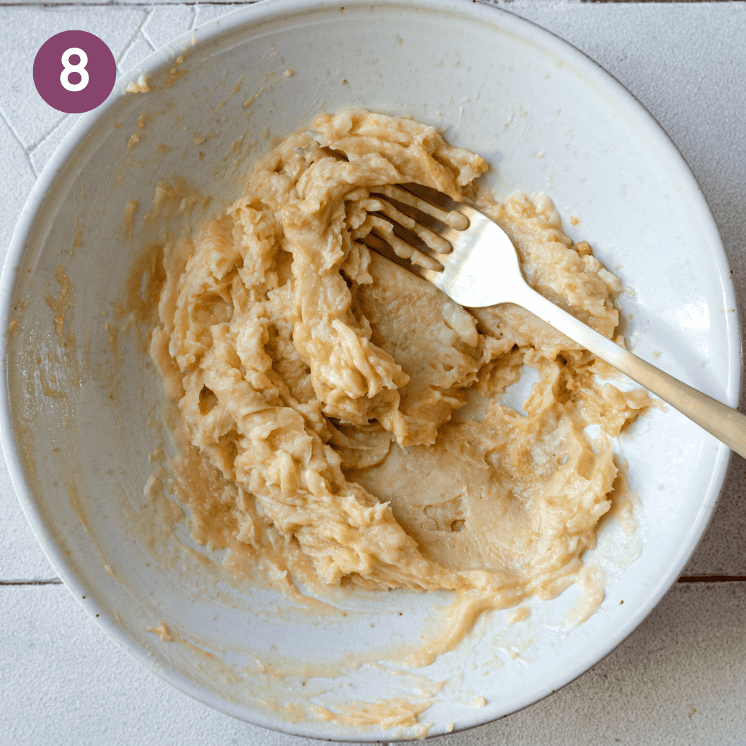 miso butter and roasted garlic creamed together in a ceramic bowl with a fork. 