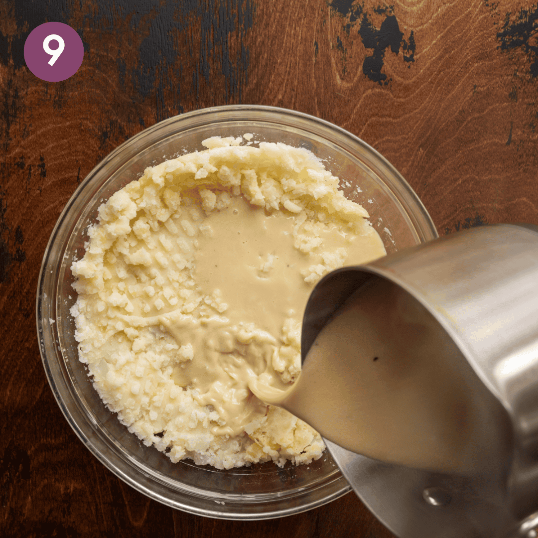 saucepan pouring melted butter-miso mixture into mashed potatoes in a glass bowl.