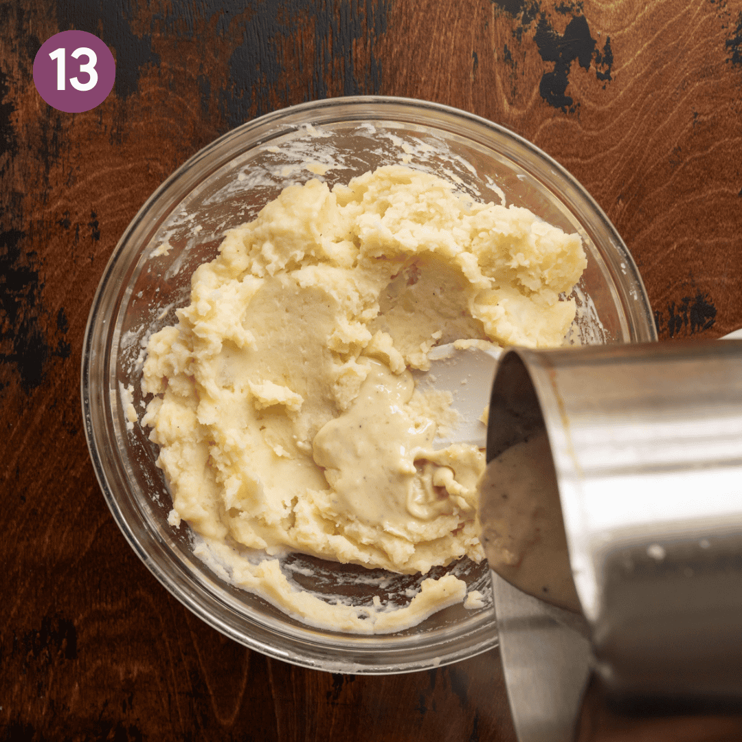 saucepan pouring melted butter-miso mixture into mashed potatoes in a glass bowl.