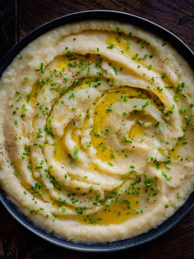 bowl of mashed potatoes with melted butter and chives.