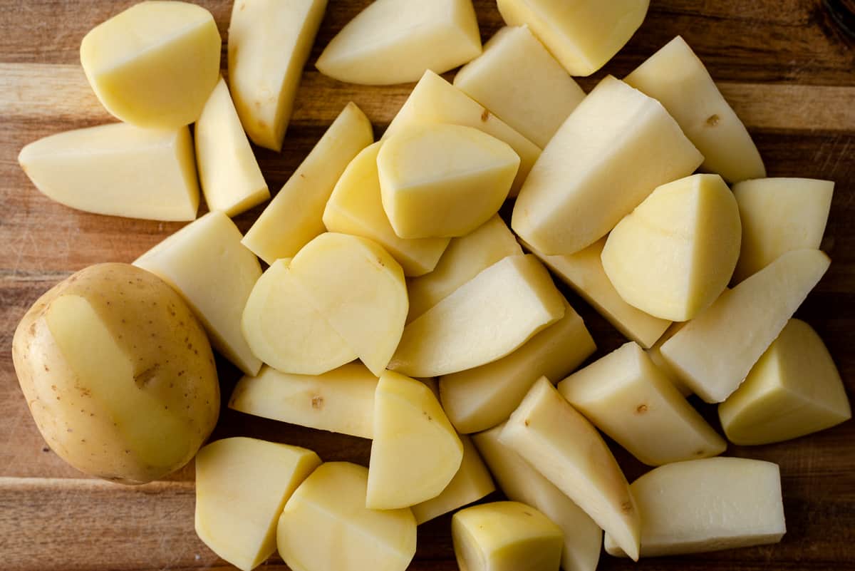 peeled and chopped potatoes on cutting board