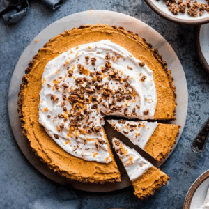 pumpkin cream tart on a marble serving tray on a table.