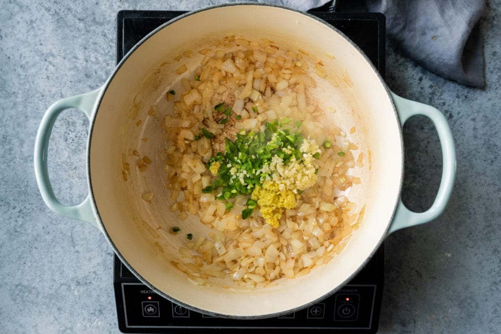 adding garlic ginger jalapeno to sauted onions in dutch oven