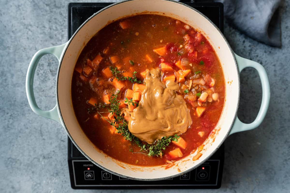 white beans, tomatoes, thyme, sweet potatoes and peanut butter added to the Dutch oven.