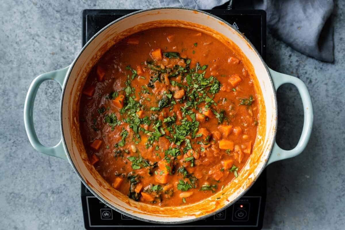 fully cooked stew topped with cilantro and lemon juice in Dutch oven.
