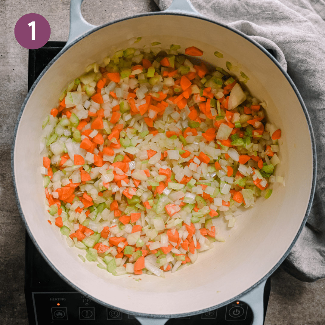 carrots, onions, and celery sautéing in olive oil in a Dutch oven.