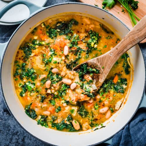 creamy white bean soup in dutch oven with wooden spoon tucked into pot