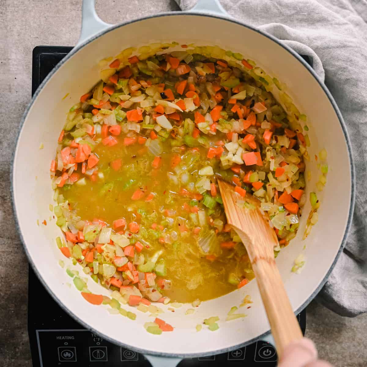 deglazing mirepoix with vegetable broth in dutch oven