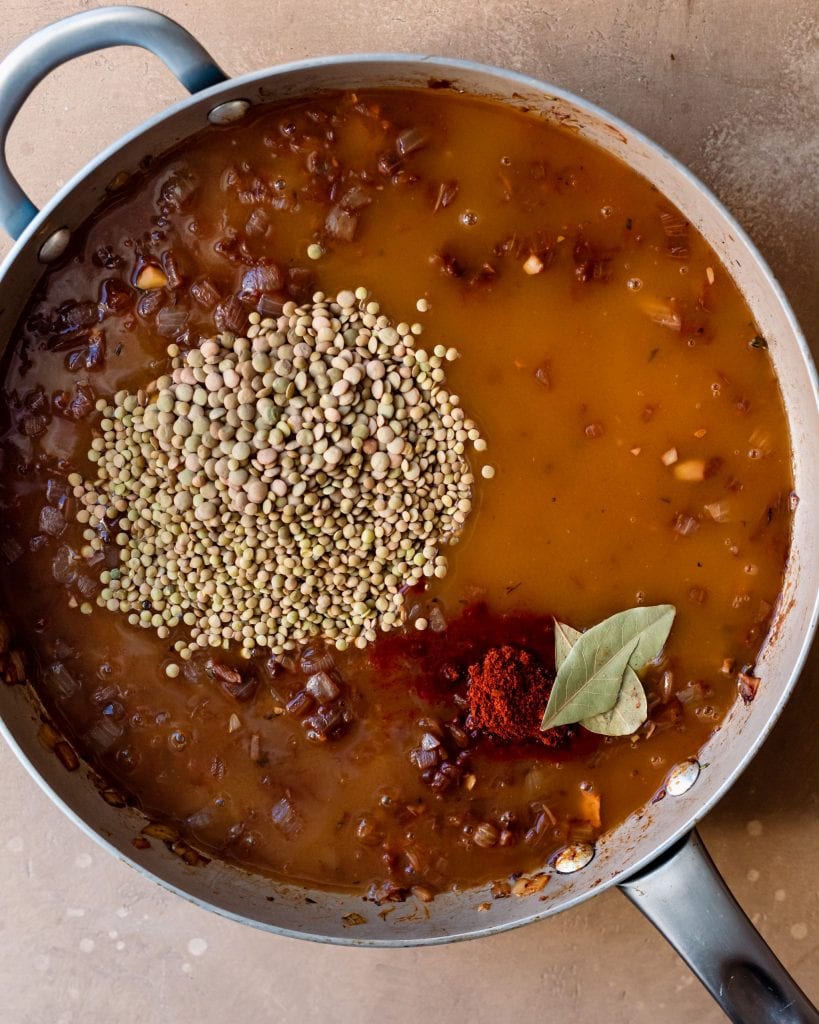 adding broth to lentil mixture