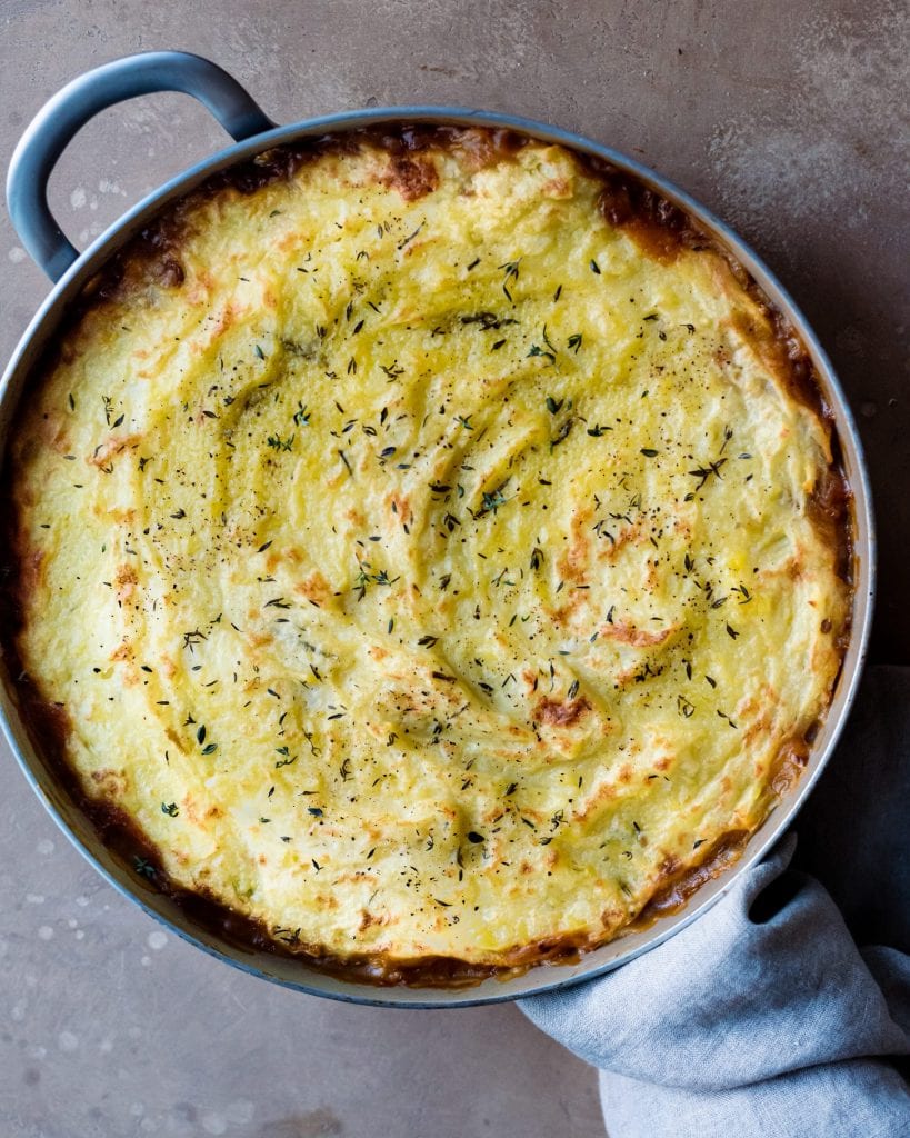 baked vegan lentil shepherd's pie in skillet with dish towel