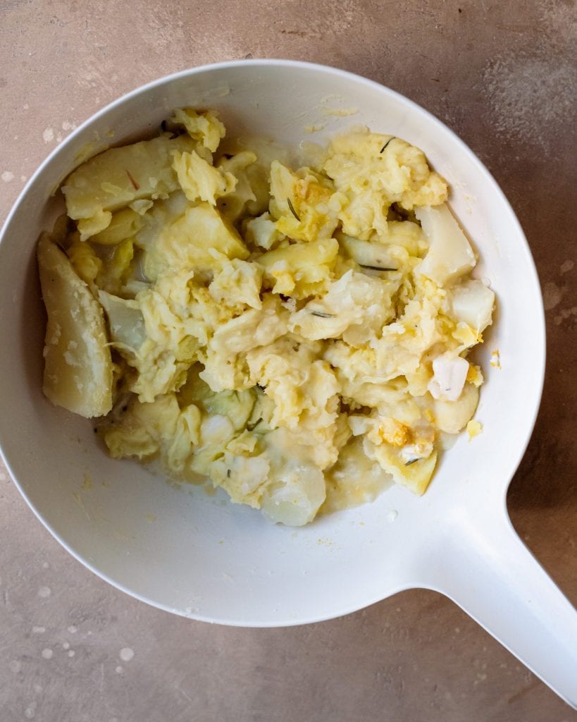 mashing cauliflower and potatoes for mashed potato topping