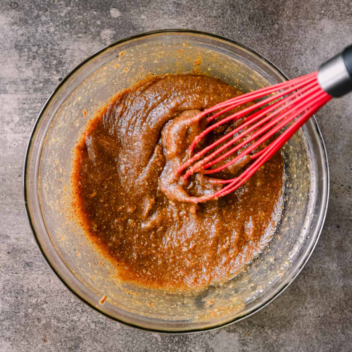 whisking almond butter with maple syrup for cookies