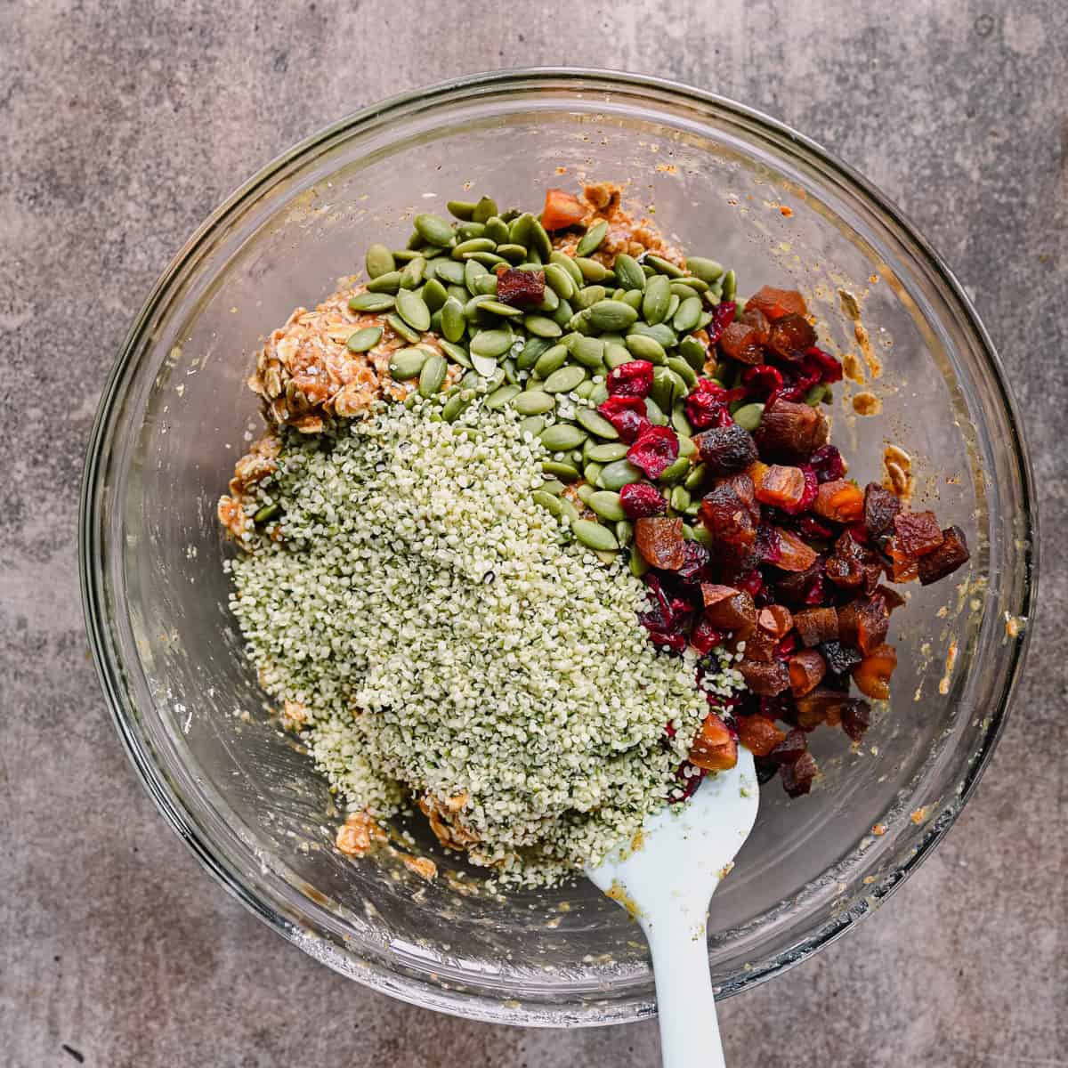 hemp seeds, pepitas and dried fruit on top of cookie dough.