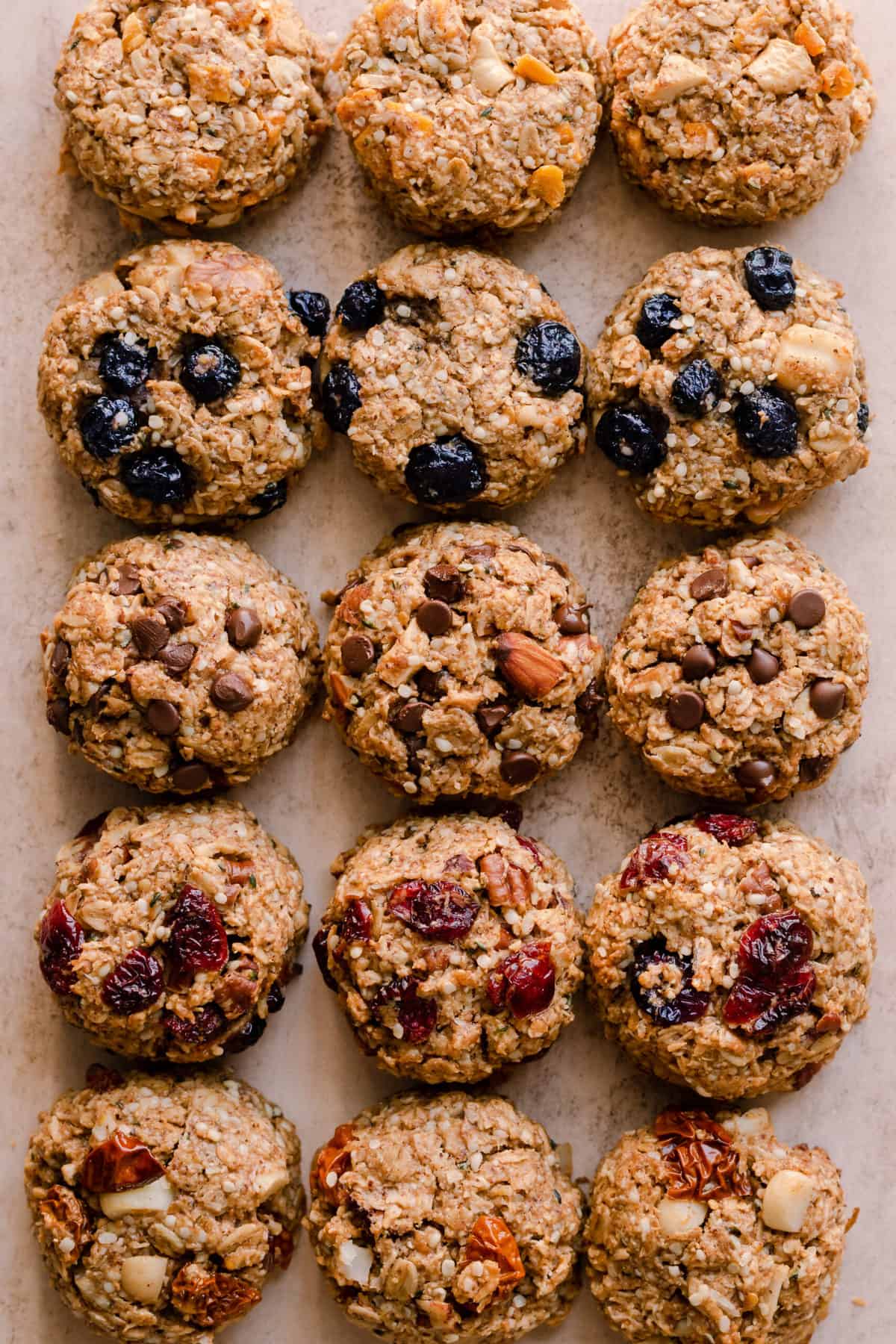 9 cookies lined up on a baking tray with parchment paper.