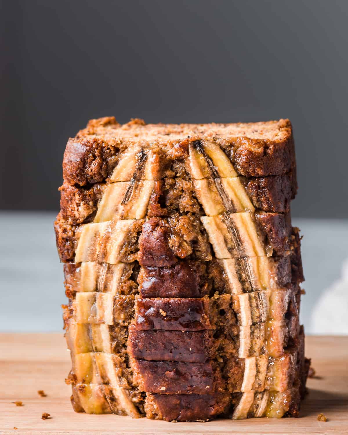 tall stack of slices of vegan banana bread with banana slices baked into the bread.