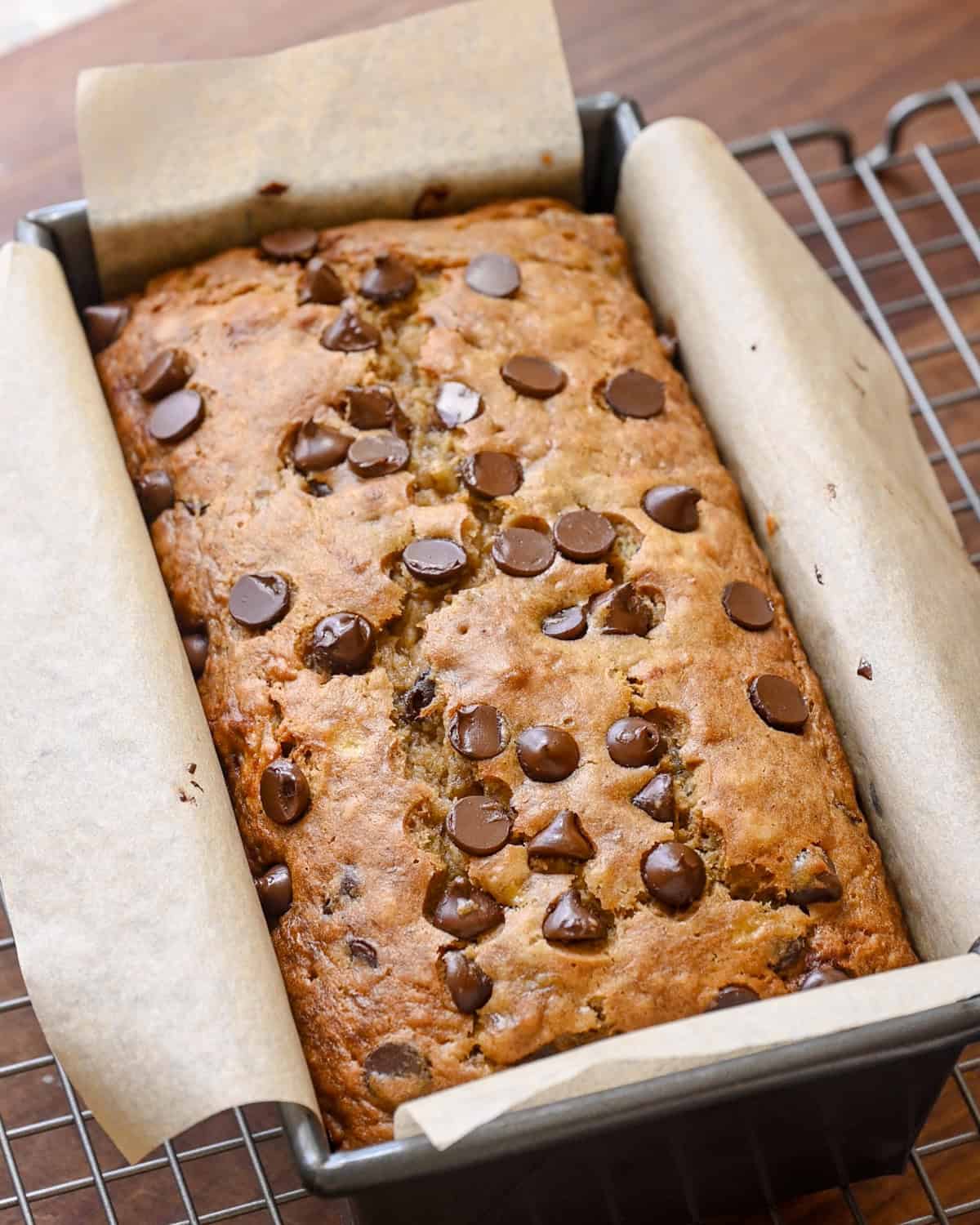 vegan banana bread with chocolate chips in a lined loaf pan.