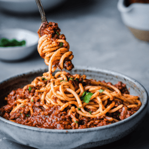 red lentil bolognese twirling on a fork