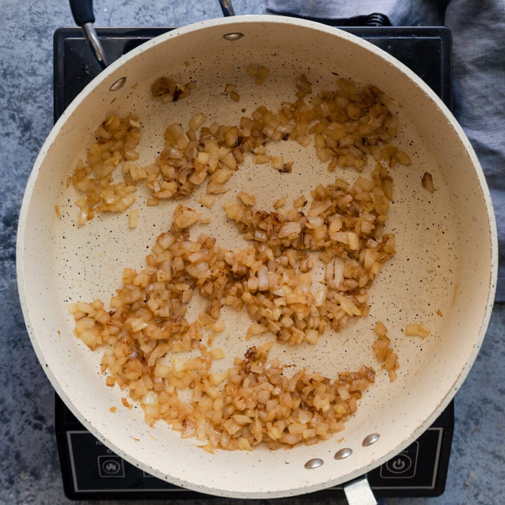 saute pan with browned onions cooking in oil
