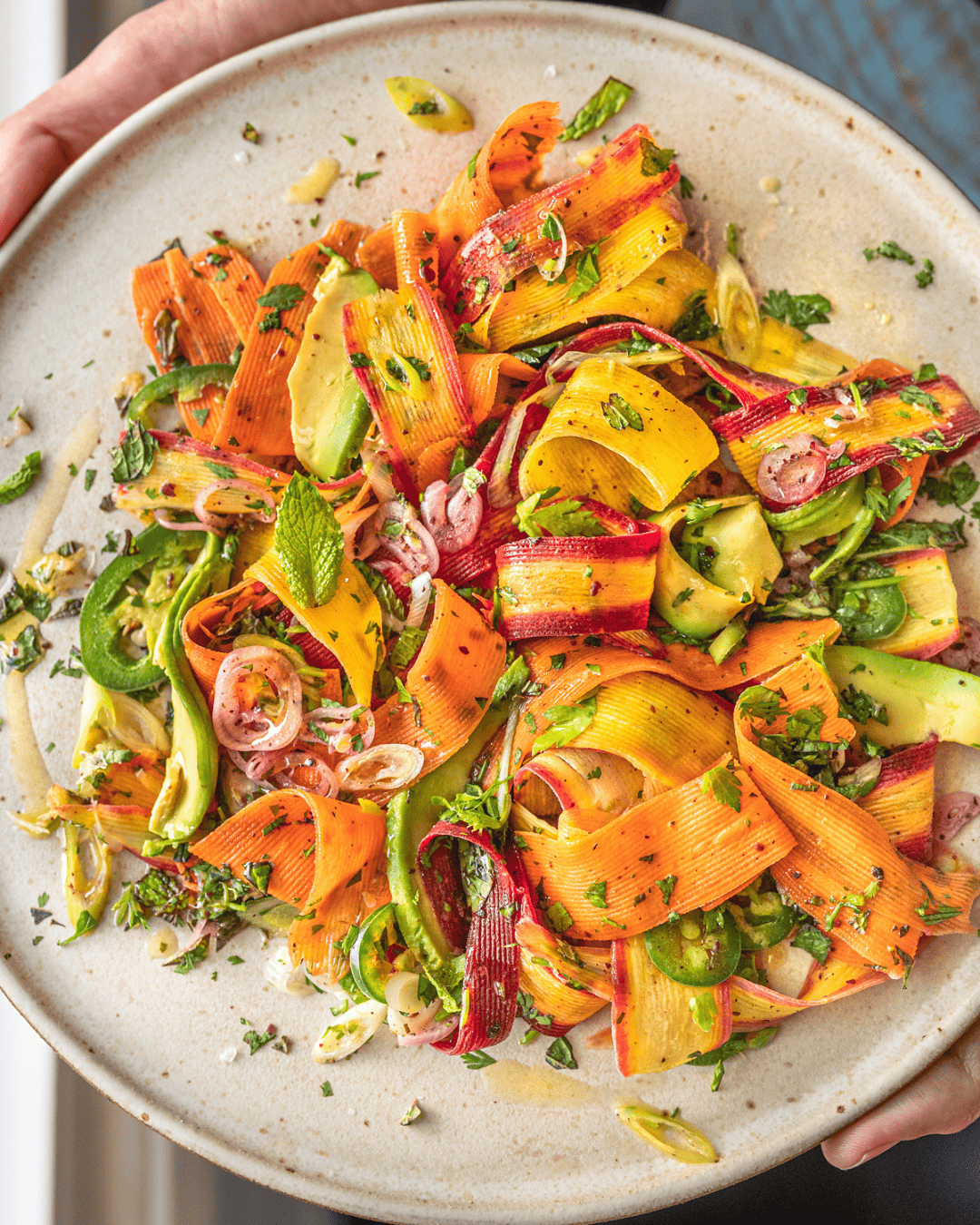 shaved carrot salad on a white plate.