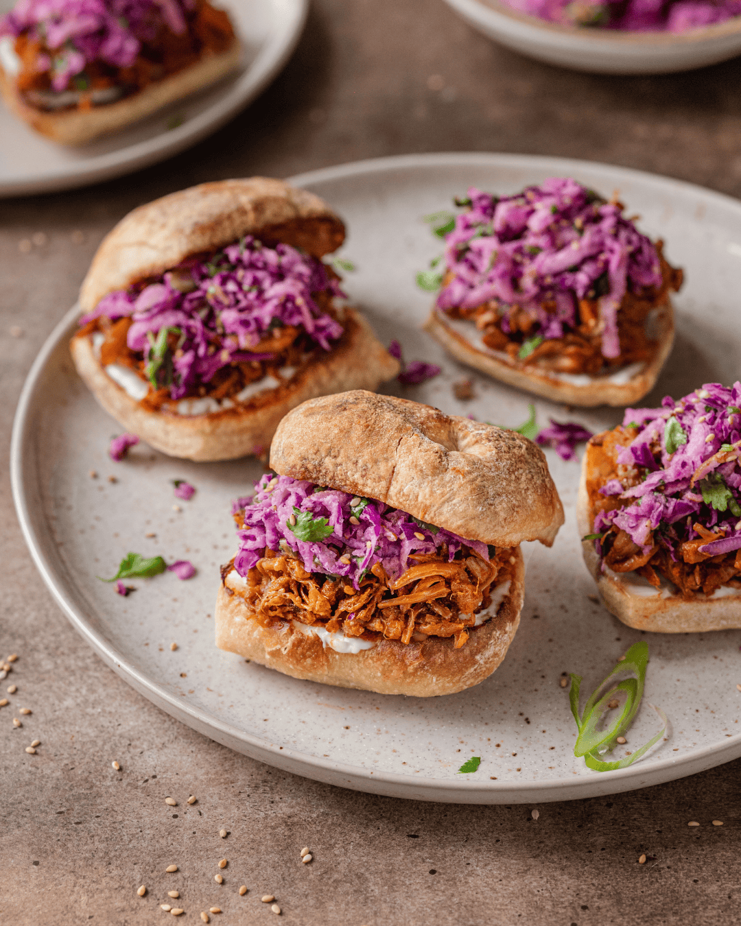 4 jackfruit sliders with slaw on a plate.