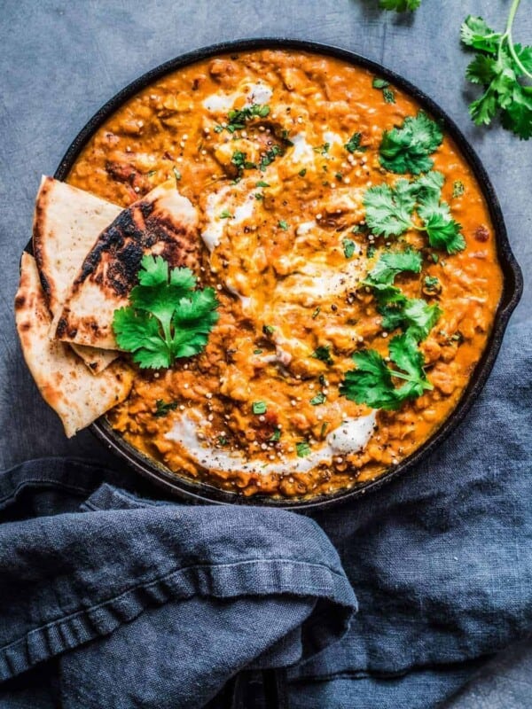 overhead shot of red lentil curry next to blue napkin