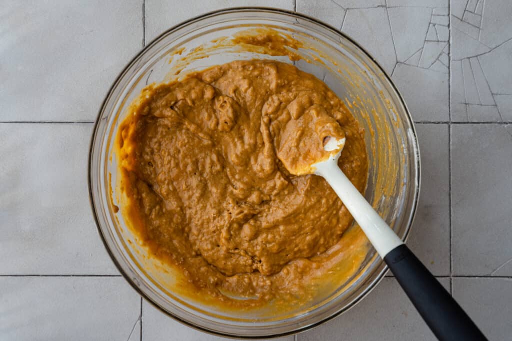 pumpkin bread batter in mixing bowl with spatula
