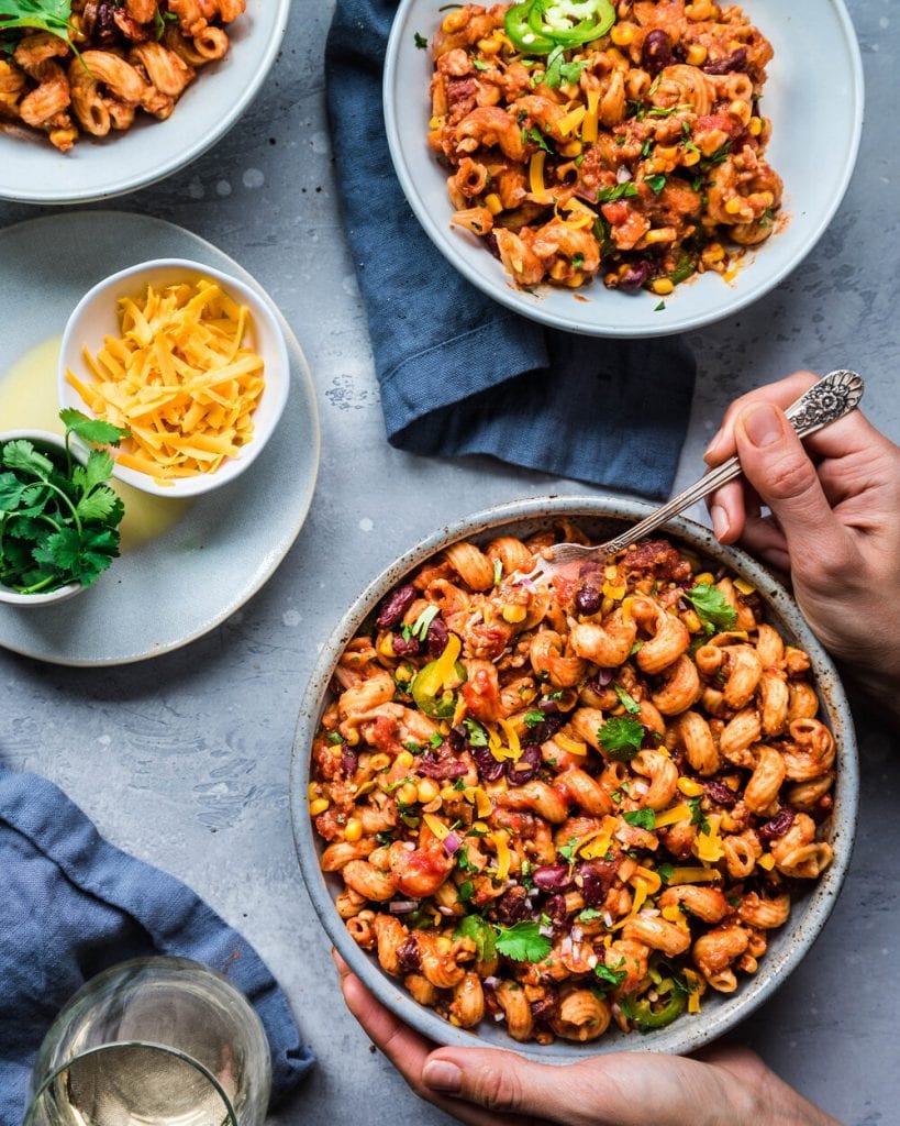 woman's hands holding bowl of chili mac