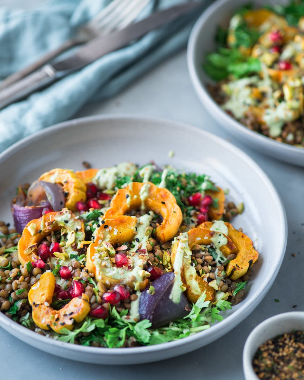 Side view of a large bowl filled with lentil salad on a grey table.