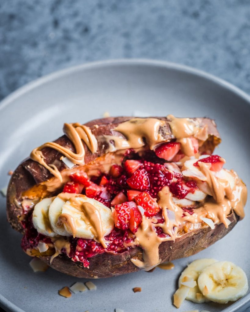 patate douce cuite au four et farcie au beurre de cacahuète, à la confiture de framboise et de chia, aux bananes et aux fraises