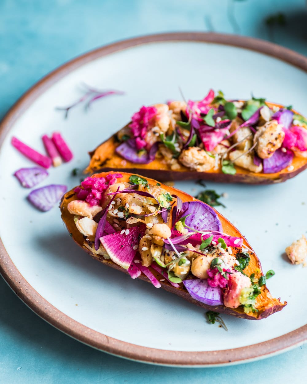 Side view of two stuffed sweet potato halves on a plate.