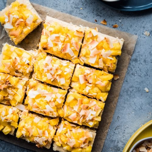 pina colada cheesecake bars on parchment paper