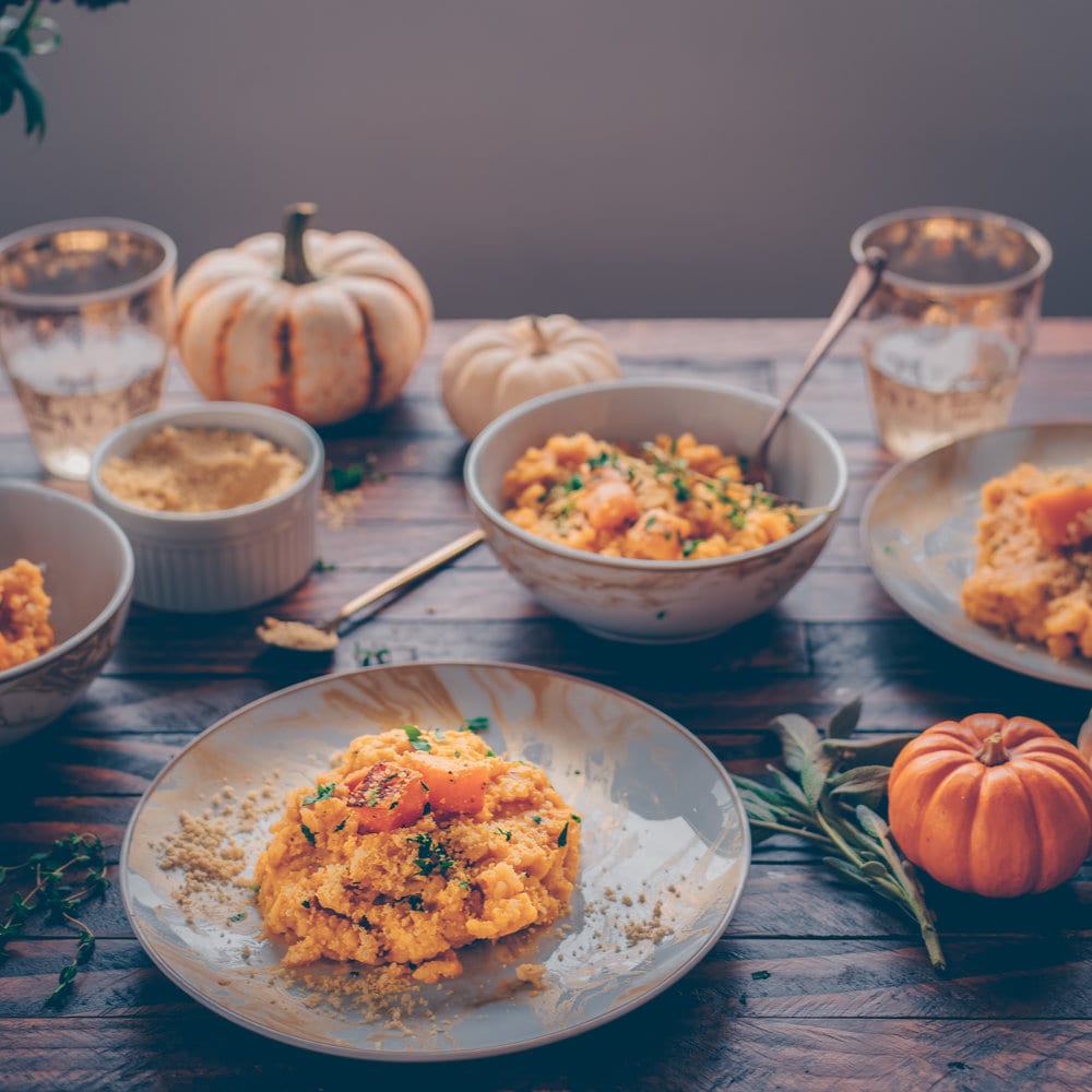 butternut squash risotto on a table alongside some other dishes.