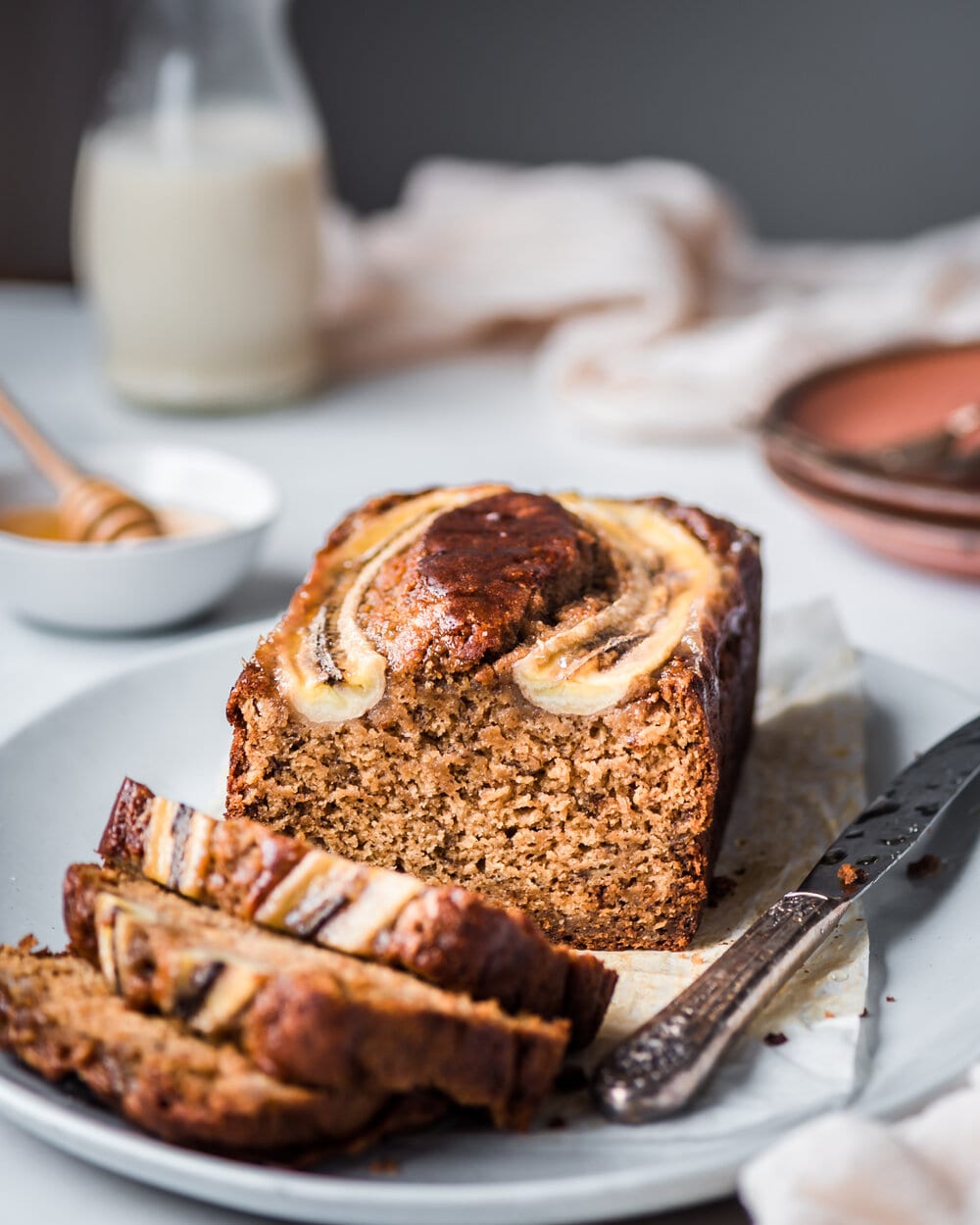 loaf of banana bread on tray with three slices 