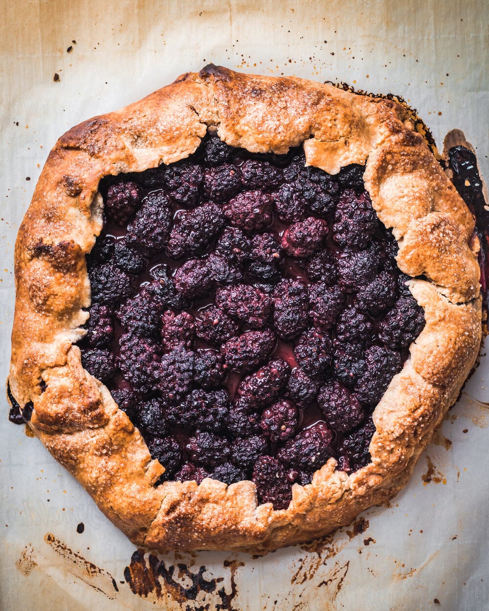 Cooked blackberry galette on a baking sheet.