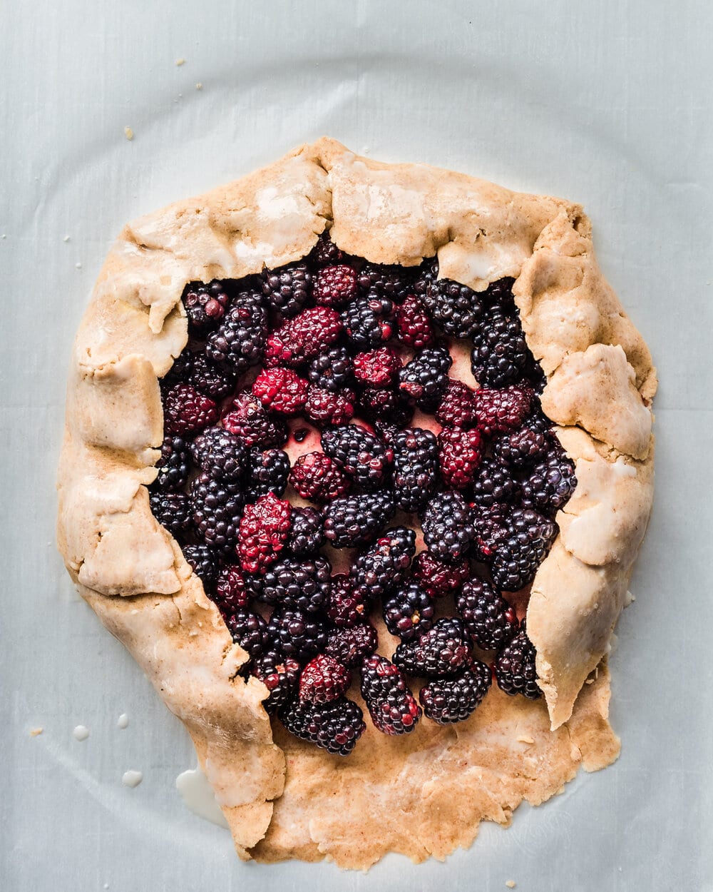 Galette dough folded over three sides of blackberries.