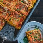 pan and plate of lasagna on a table.