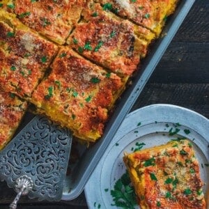 pan and plate of lasagna on a table.