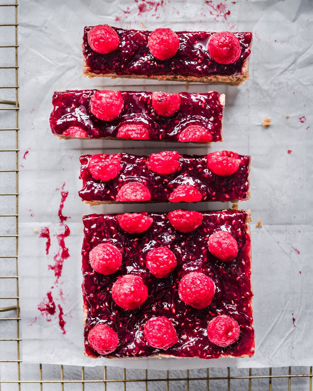 Overhead view of pb&j bars on parchment paper on a cooling rack.