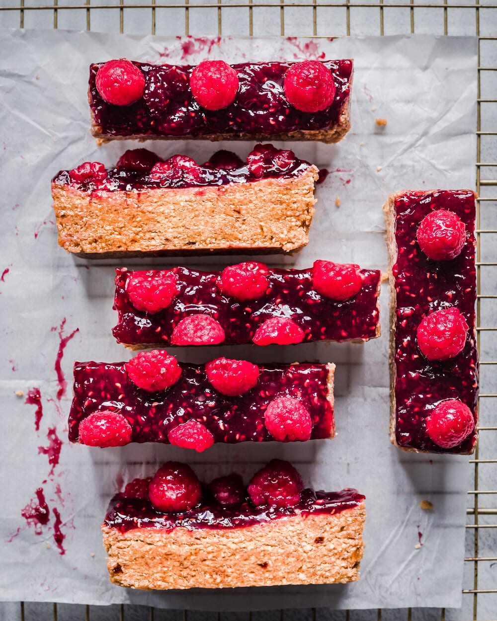 Overhead view of pb&j bars on parchment paper on a cooling rack.