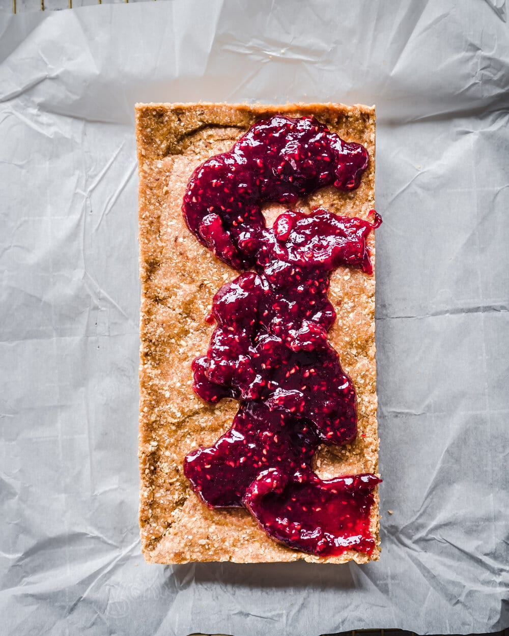 Full peanut butter bar with jam globs before the jam is spread out.