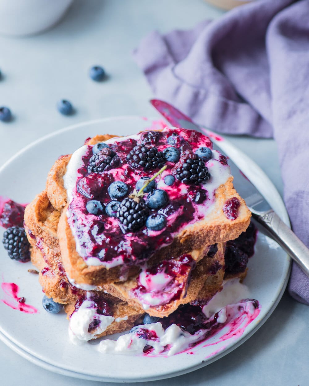 Stack of berry french toast on a white plate.