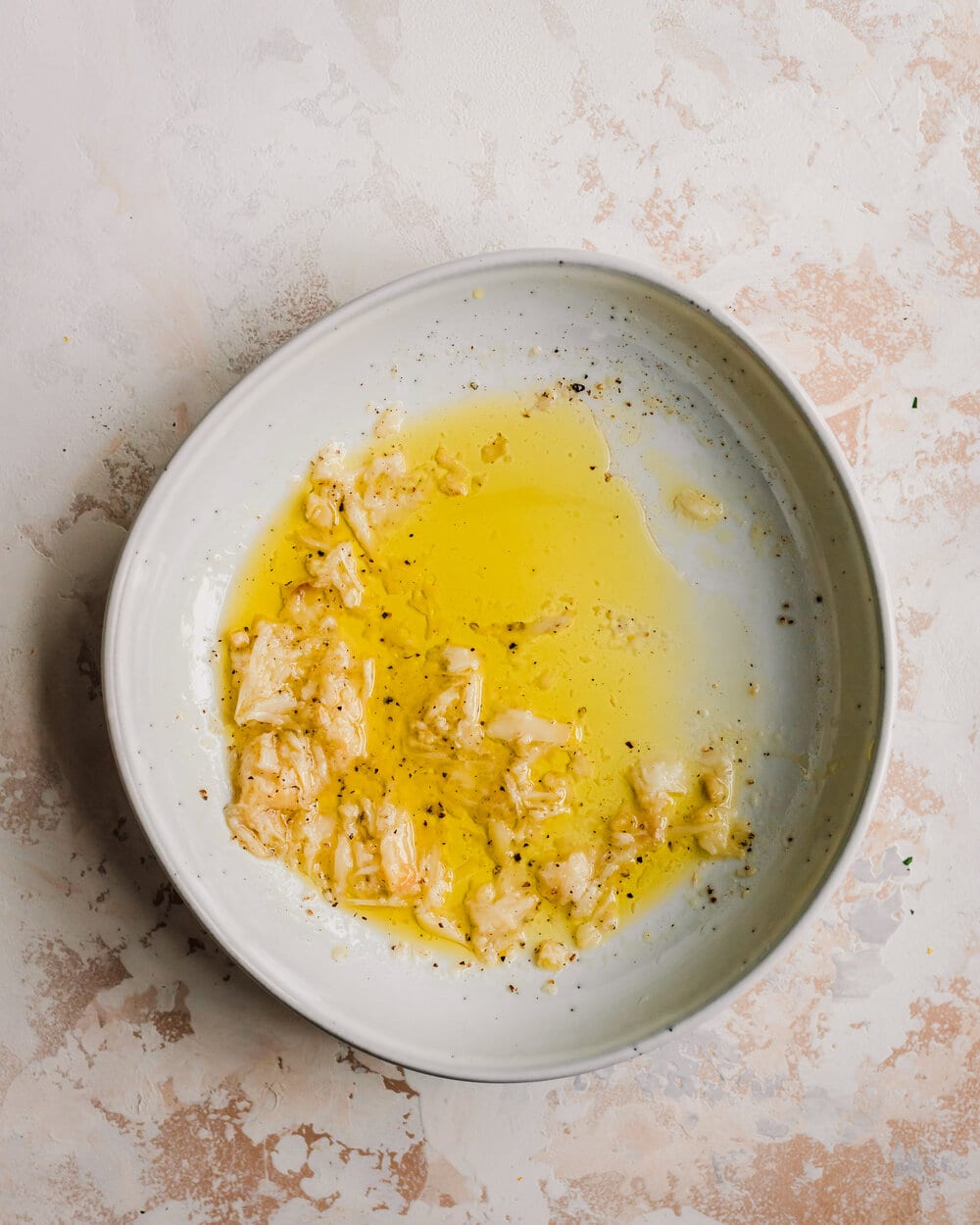 roasted garlic lemon vinaigrette with olive oil in a ceramic bowl. 